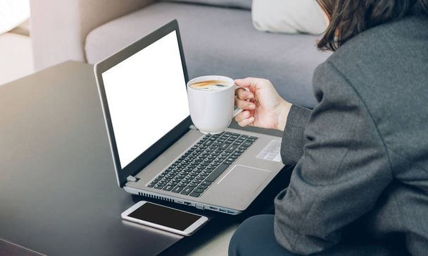 Podnikatelka, držící šálek kávy, pracují na notebooku a mobilní na - Fotografie, Obrázek