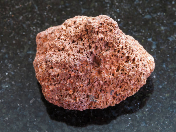 красный камень пемзы на темном фоне
 - Фото, изображение