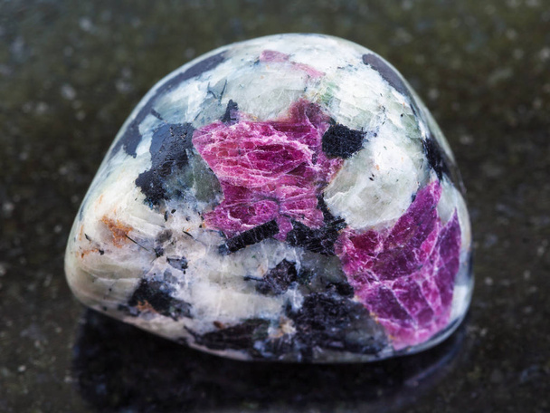 рассыпались розовые кристаллы Корунда в скале в темноте
 - Фото, изображение