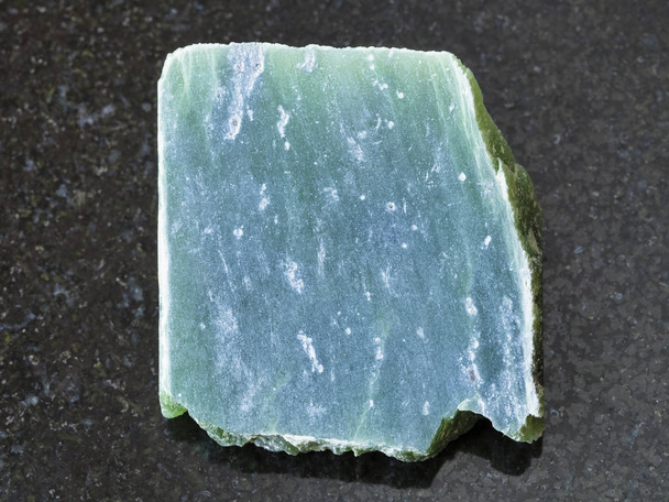 losa de piedra de nefrita cruda sobre fondo oscuro
 - Foto, imagen