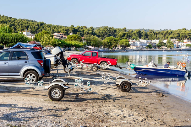 Lossen van kleine motorboten in zeewater - Foto, afbeelding