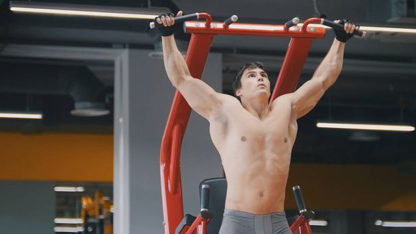 М'язистий молодий чоловік тягнеться в спортзал, крупним планом
 - Фото, зображення
