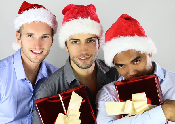Group of happy cheerful multiracial friends in christmas hats celebrating  - Photo, Image