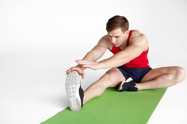 Young sportsman stretching on map - Zdjęcie, obraz