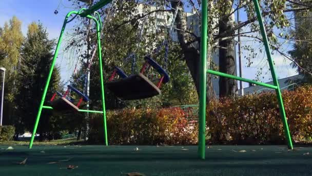 Loneli swings swing on the playground. - Кадри, відео