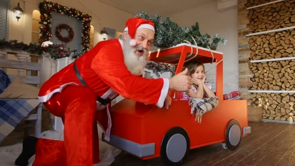 Goede vrienden Santa en meisje die zich voordeed op camera op veranda van grote huis ingericht voor Kerstmis - Video