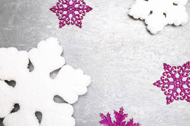 Decorative snowflake white and pink on grey background. Christmas greeting card. Copy space. Top view. - Photo, Image