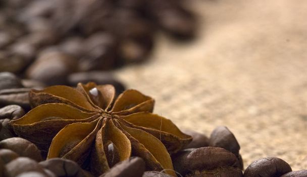 coffee beans and star anise on coarse fabric - Photo, image