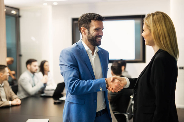 Picture of businessman and businesswoman shaking hands at meeting - Photo, image