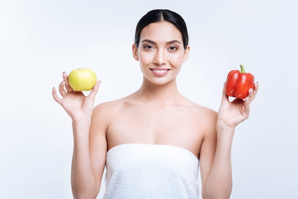 Pleasant woman posing with apple and bell pepper - Foto, Bild
