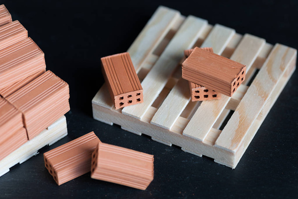 Close-up van gevallen bakstenen op houten palle - Foto, afbeelding