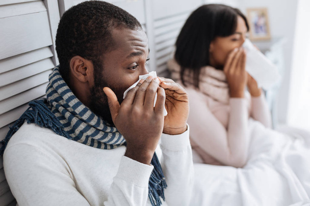 Two ill people sneezing while sitting together - Photo, Image
