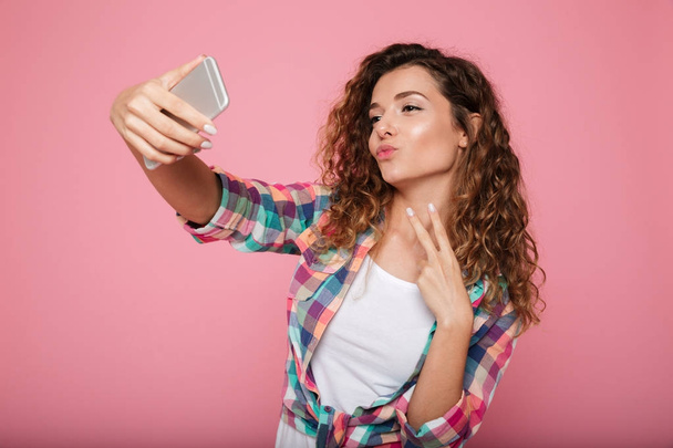 Young beautiful woman making selfie on smartphone isolated - Фото, зображення