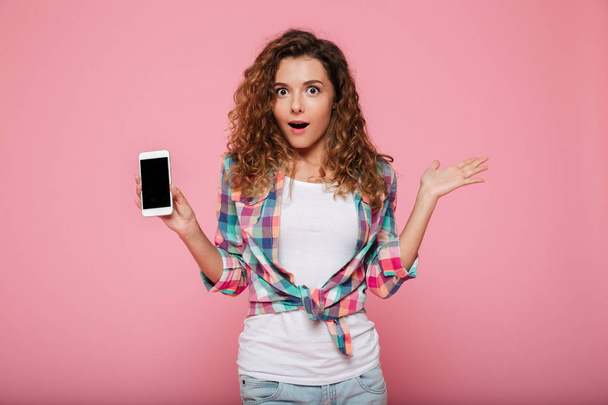 Señora sorprendida mostrando teléfono inteligente con pantalla en blanco aislado
 - Foto, Imagen