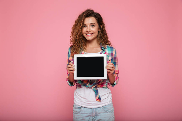 Cheerful lady showing tabler computer with blank screen isolated - Photo, image
