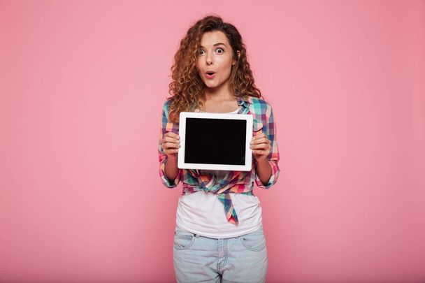 Cheerful lady showing tabler computer with blank screen isolated - Foto, Bild