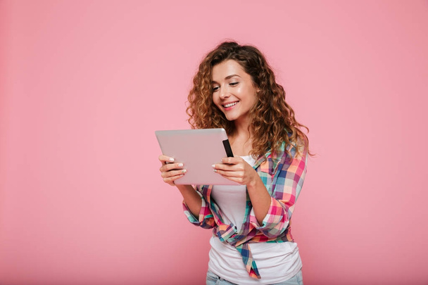 Young caucasian brunette lady using tablet computer isolated over pink - Photo, Image