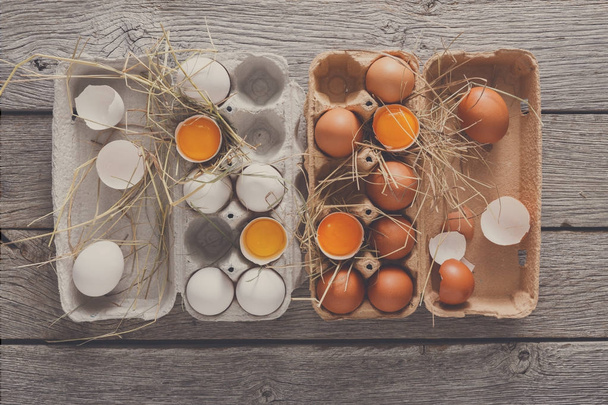 Tuoreet ruskeat munat kartonkikotelossa maalaispuulla
 - Valokuva, kuva