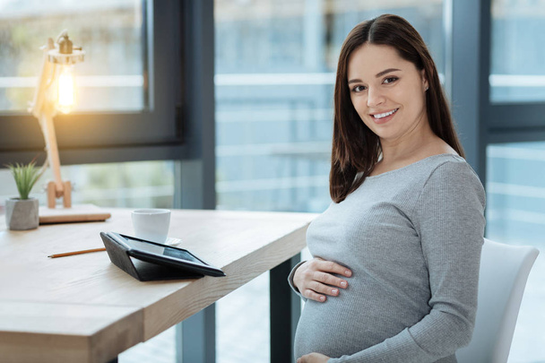 Close up of gracious pregnant woman with a smile - Foto, afbeelding