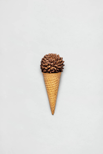 Coffee cone. Creative concept photo of waffle cone filled with coffee on grey background. - Фото, зображення