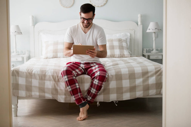 man using tablet in bedroom - Zdjęcie, obraz