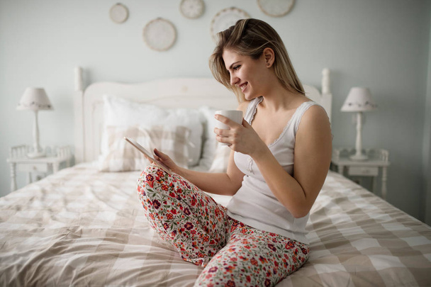 woman using tablet in bedroom - Foto, Bild
