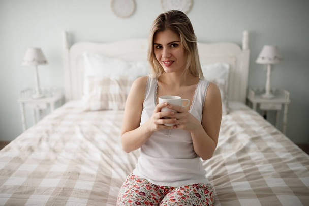 beautiful woman drinking coffee on bed - Foto, Imagen