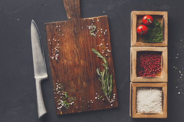 Wooden desk and diverse spices on dark background - Photo, Image