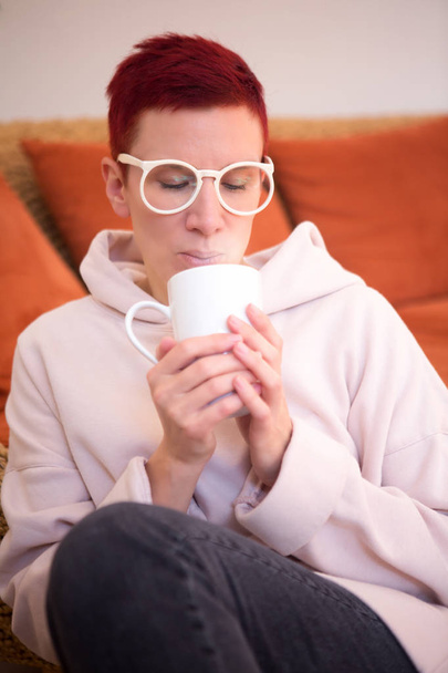 portrait of sitting on couch with holding a cup - Foto, Bild