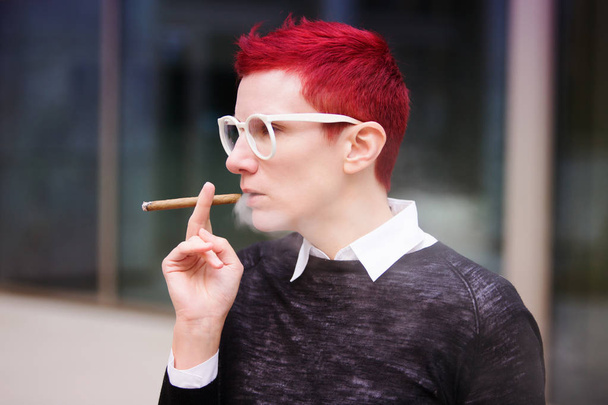 portrait of red-haired woman smoking a cigar - 写真・画像
