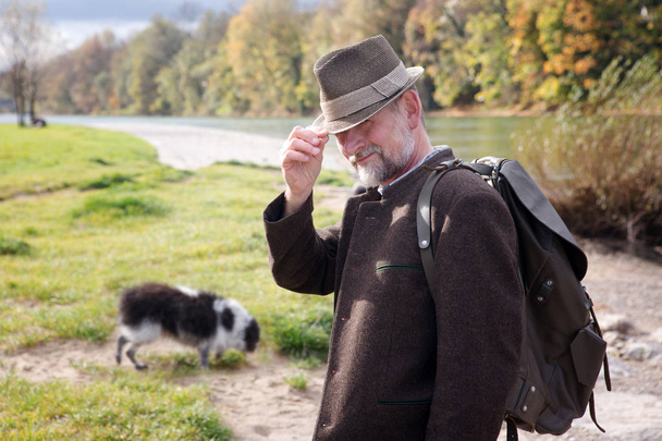 bavarian man by the river with his dog - Фото, зображення