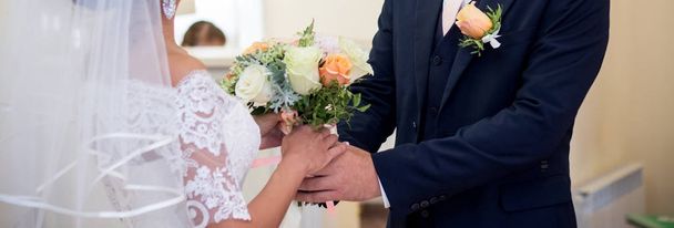 Bride and groom holding wedding bouquet with roses - Φωτογραφία, εικόνα