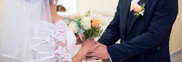 Bride and groom holding wedding bouquet with roses - Фото, зображення