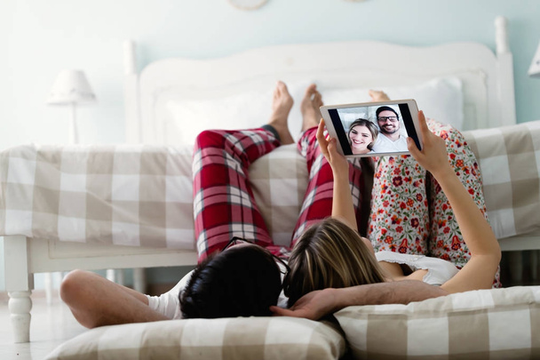 couple using tablet in bedroom - Foto, afbeelding