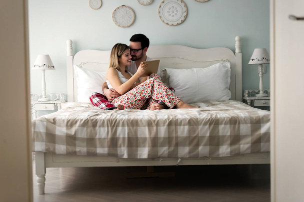 couple using tablet in bedroom - Фото, изображение