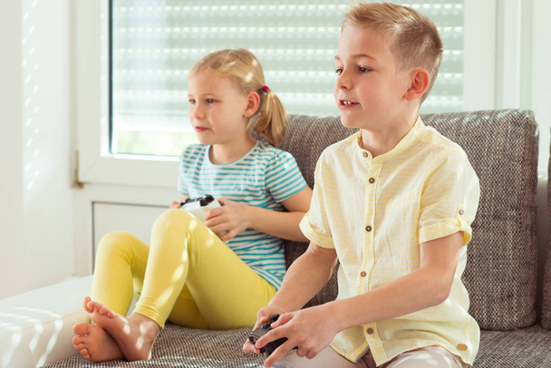 Two happy children playing video games at home - Zdjęcie, obraz