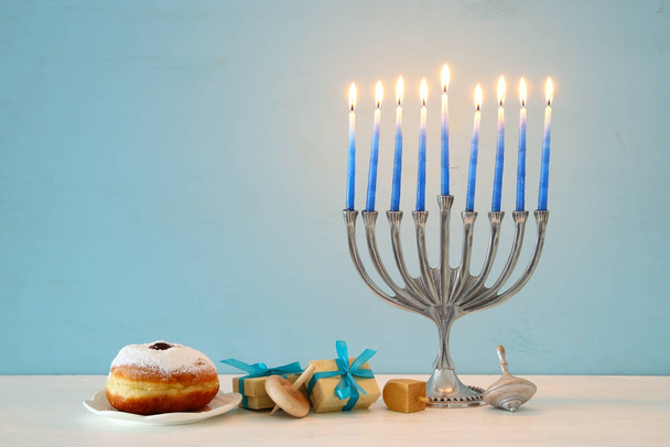 image of jewish holiday Hanukkah background with traditional spinnig top, menorah (traditional candelabra) - Фото, изображение