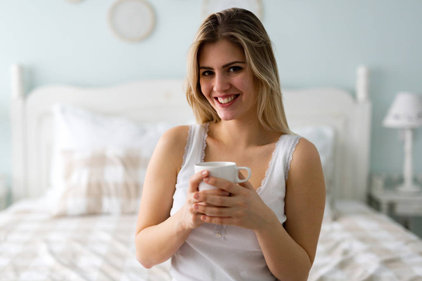 Young beautiful woman sitting on bed  - Foto, Bild