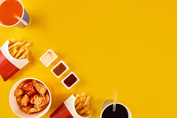 Fast food yemek Sarı zemin üzerine. Fast food kızarmış tavuk ve patates kızartması ayarlayın. Lokanta götürün. - Fotoğraf, Görsel