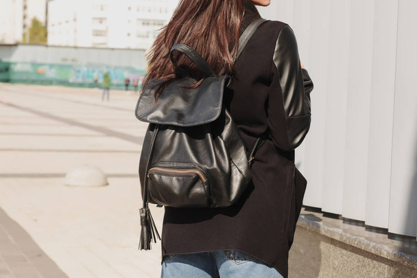 Trendy vestida modelo morena posando witn un backpa de cuero negro
 - Foto, Imagen