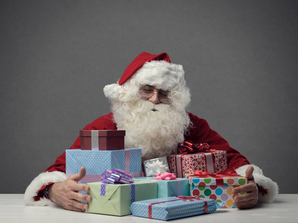 Santa Claus holding gifts - Фото, зображення