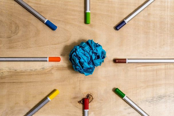 lápis de cor alinhados em torno de uma bola azul de papel
 - Foto, Imagem