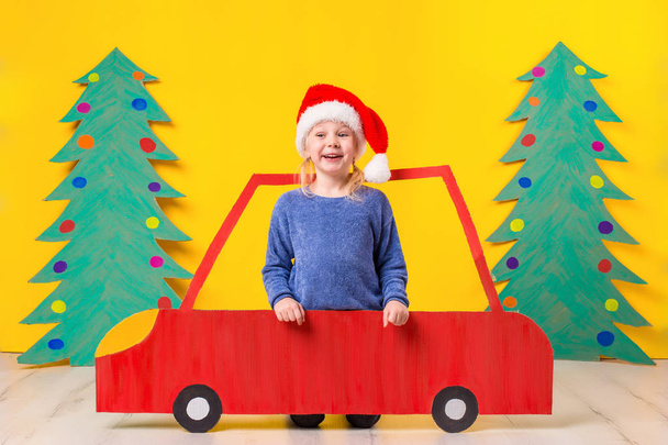 Çocuk Noel şapka karton bir araba ile. Noel kavramı. Yeni yıl tatilleri. - Fotoğraf, Görsel
