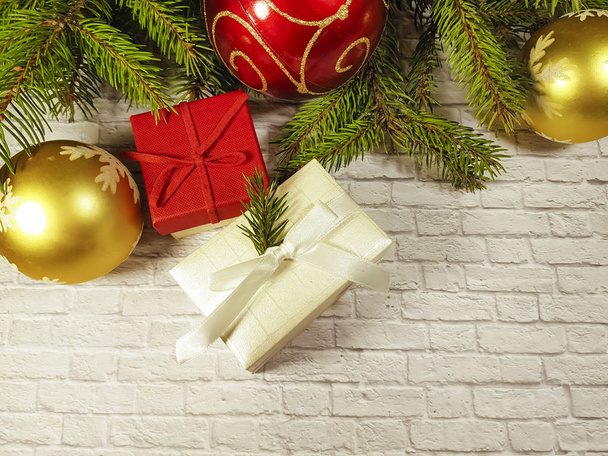 ramo de uma árvore de Natal uma parede de pedra, um brinquedo de árvore de Natal, uma caixa de presente
 - Foto, Imagem