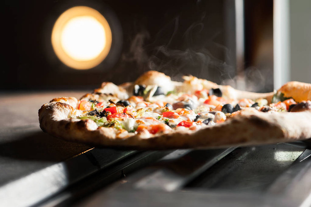 Heerlijke Pizza met een heleboel ingridients gebakken in de oven - Foto, afbeelding