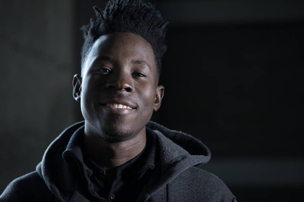 Rapper african man smiling portrait in darkness - Foto, Imagem