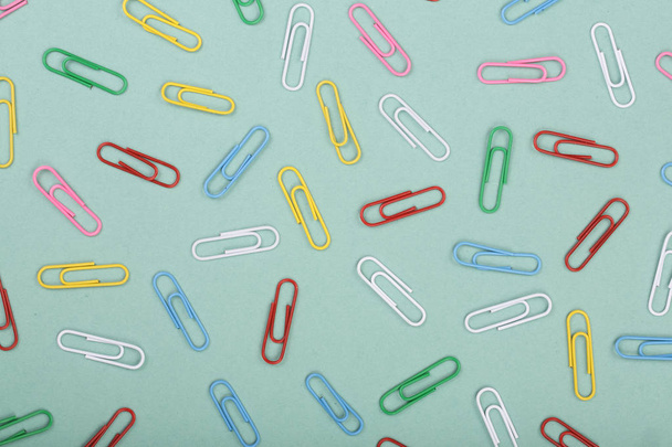 colorful paper clips on green background. Top view. Flat lay pattern - Foto, Bild