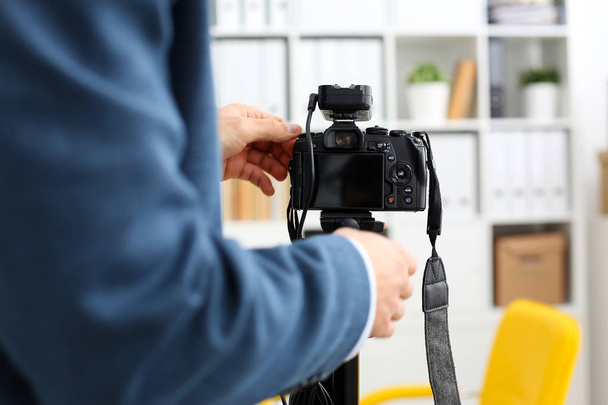 Braços masculinos em terno montar câmara de vídeo para tripé
 - Foto, Imagem