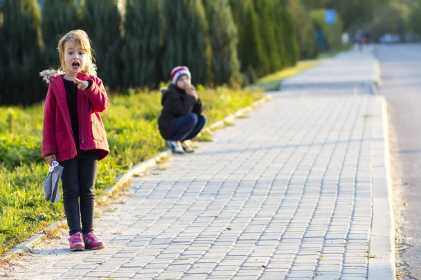 Ein kleines Mädchen und ein Junge spielen im Freien. Aktivitäten für Kinder. - Foto, Bild