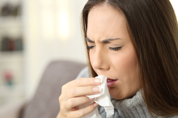 Ill woman coughing using a tissue - Фото, зображення